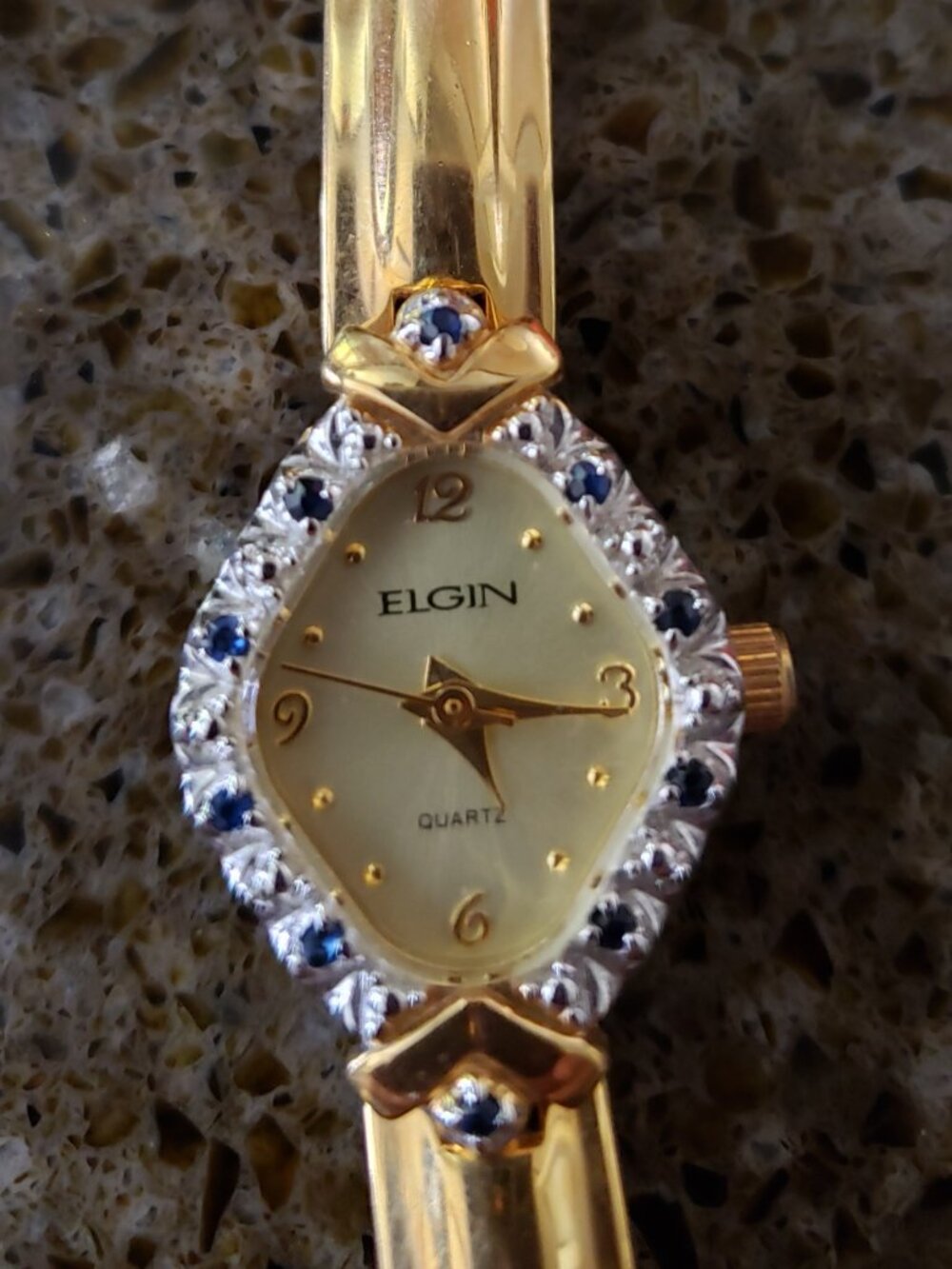 Elgin gold tone watch with saphire and diamond chips around face